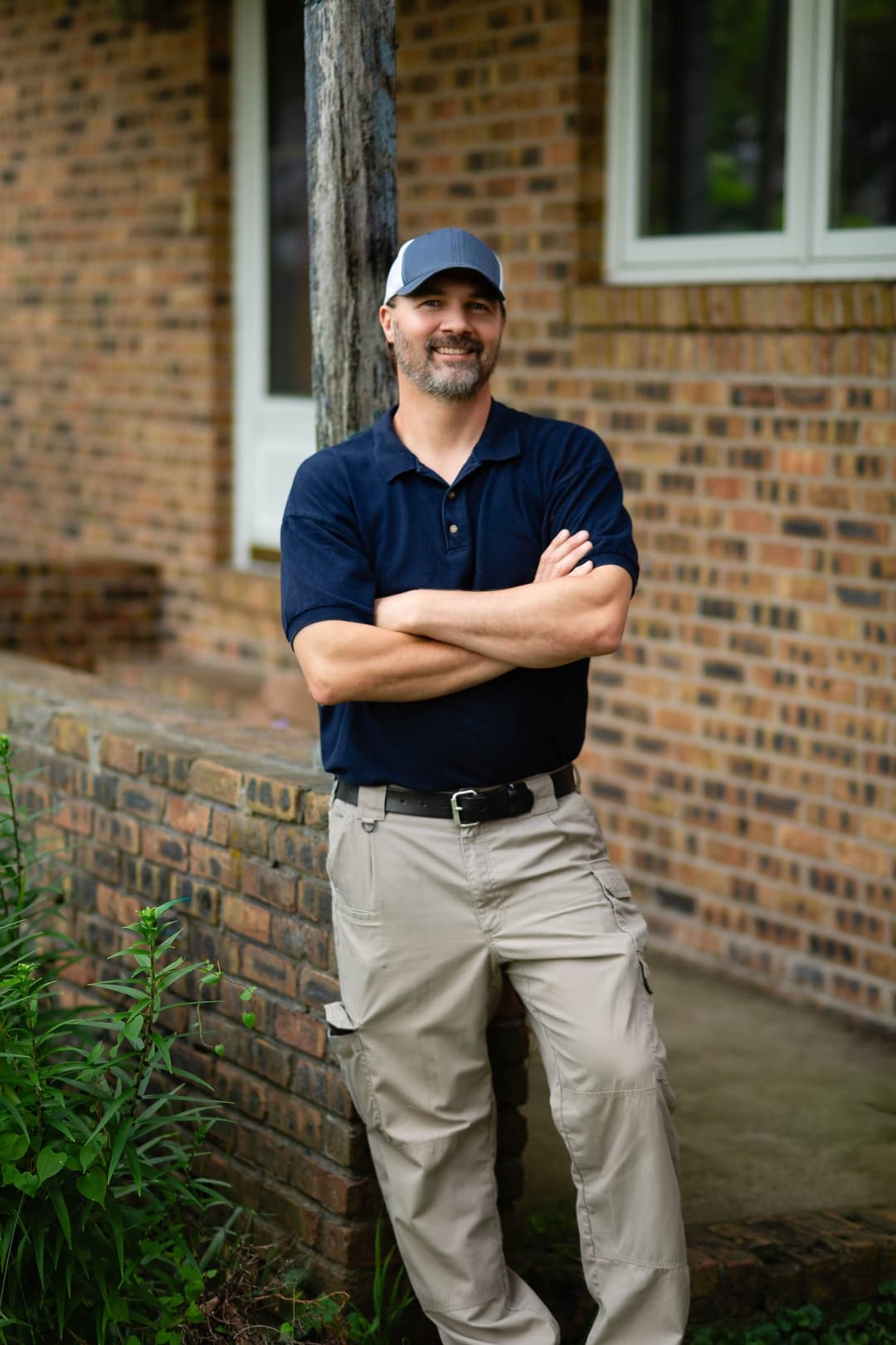 Mike Lacheta, Owner & Lead Inspector, standing in front of a brick home