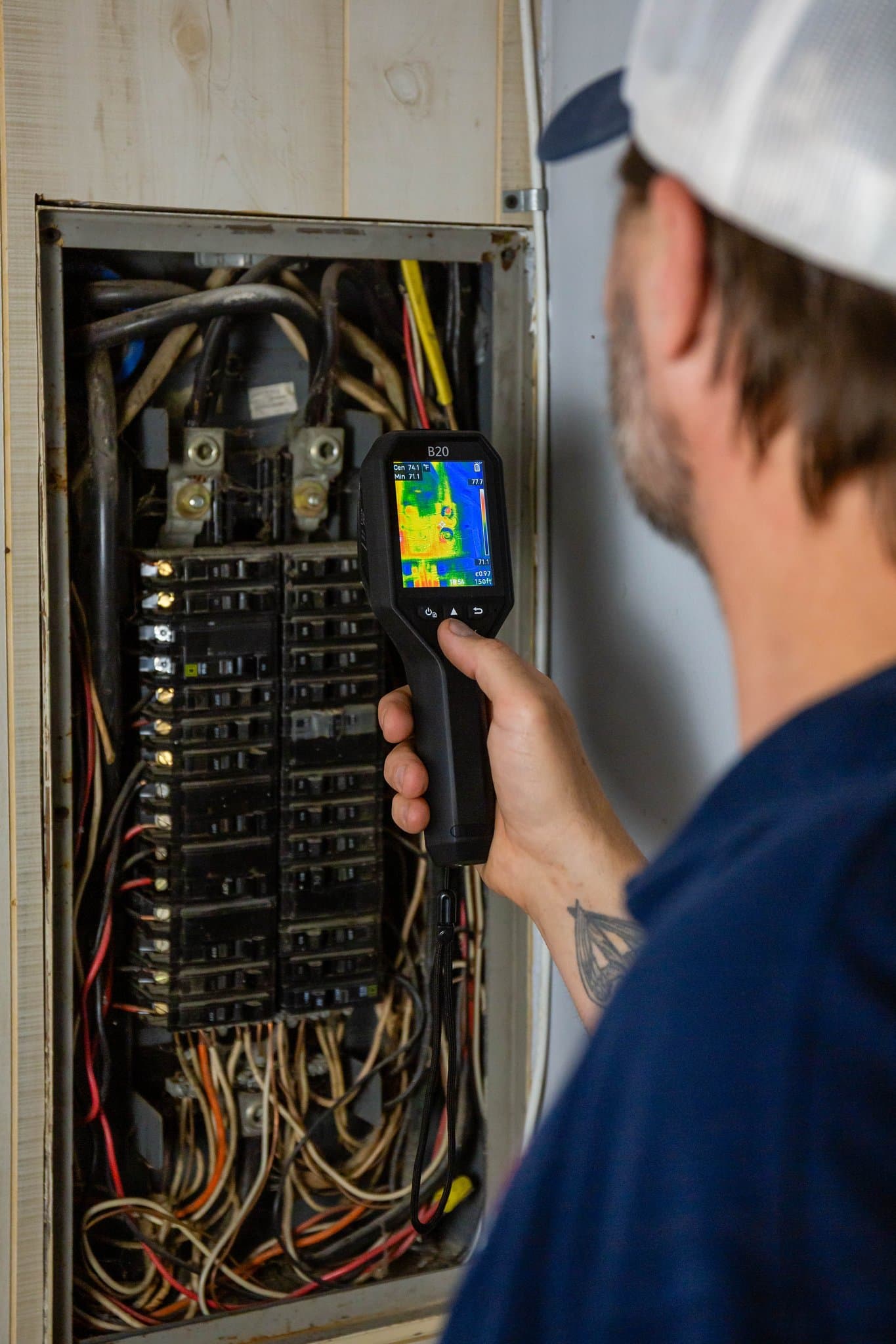 Mike Lacheta using a thermal imaging camera to inspect an electrical panel
